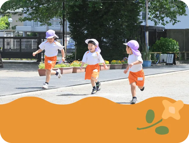 広い園庭で走る子どもたち
