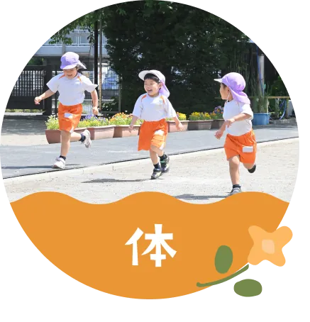 体 広い園庭で走る子どもたち