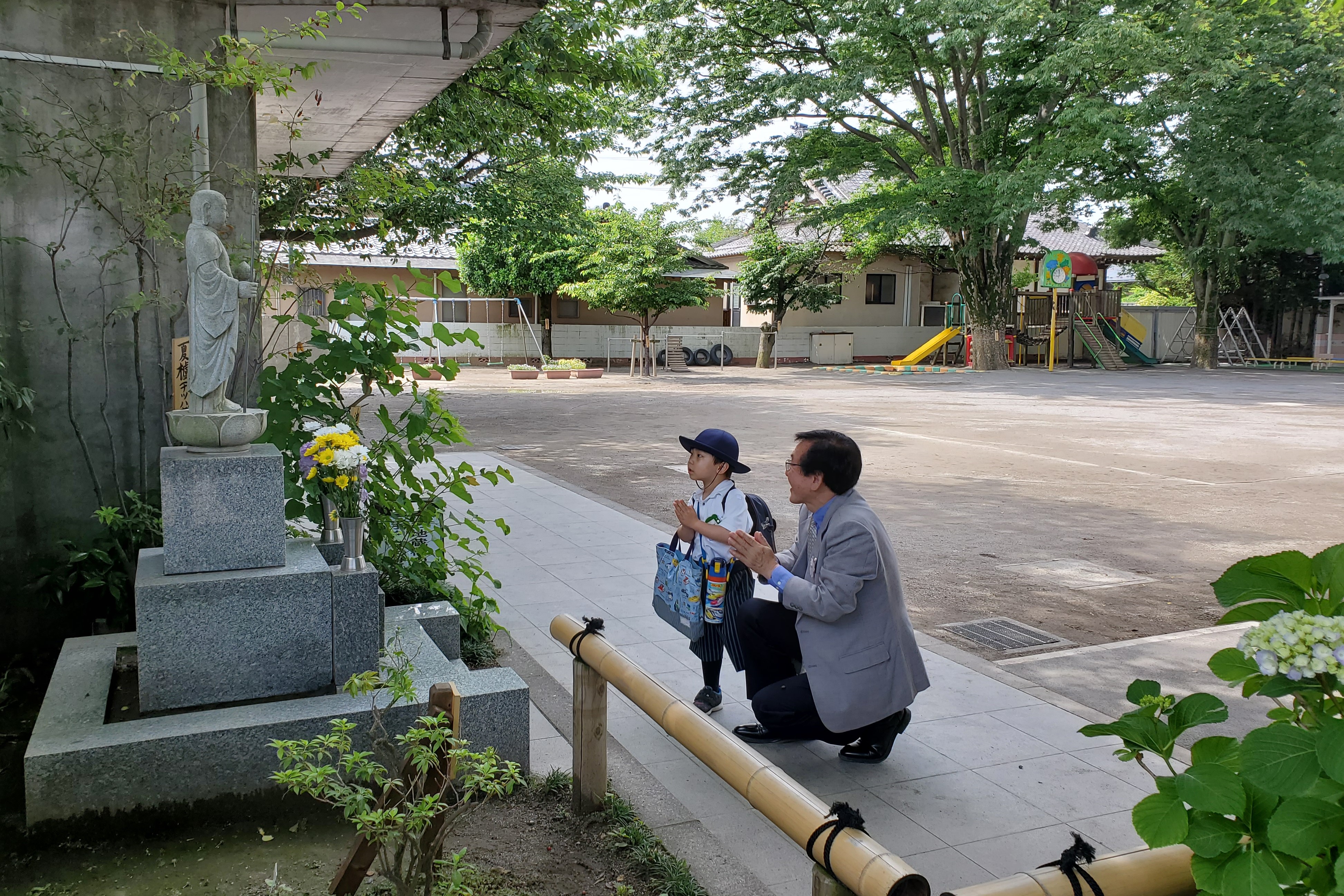 お地蔵様の前で手を合わせる