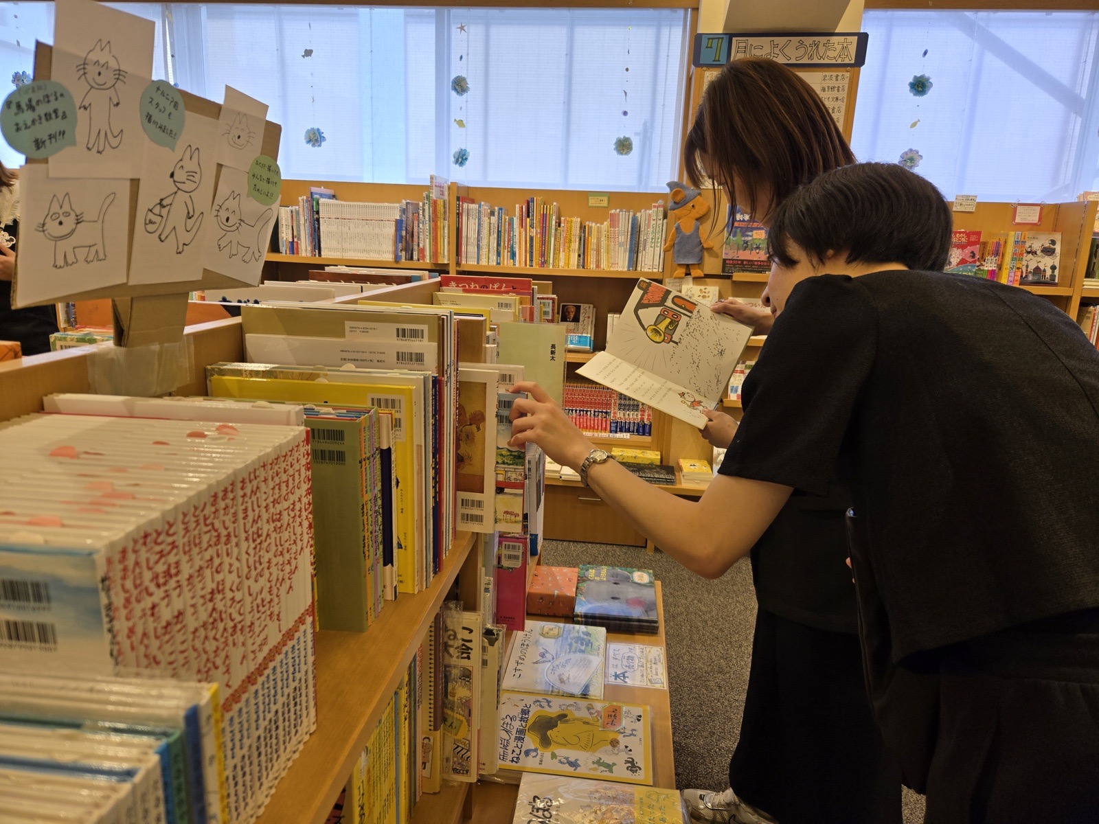 書店で子どもたちと読む絵本を選ぶ職員