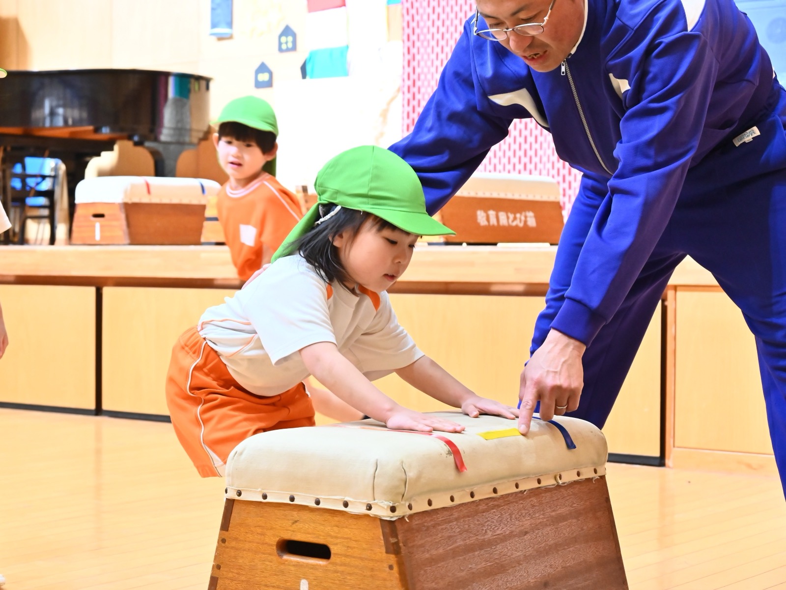 講師の指導を受けて跳び箱に挑戦する園児